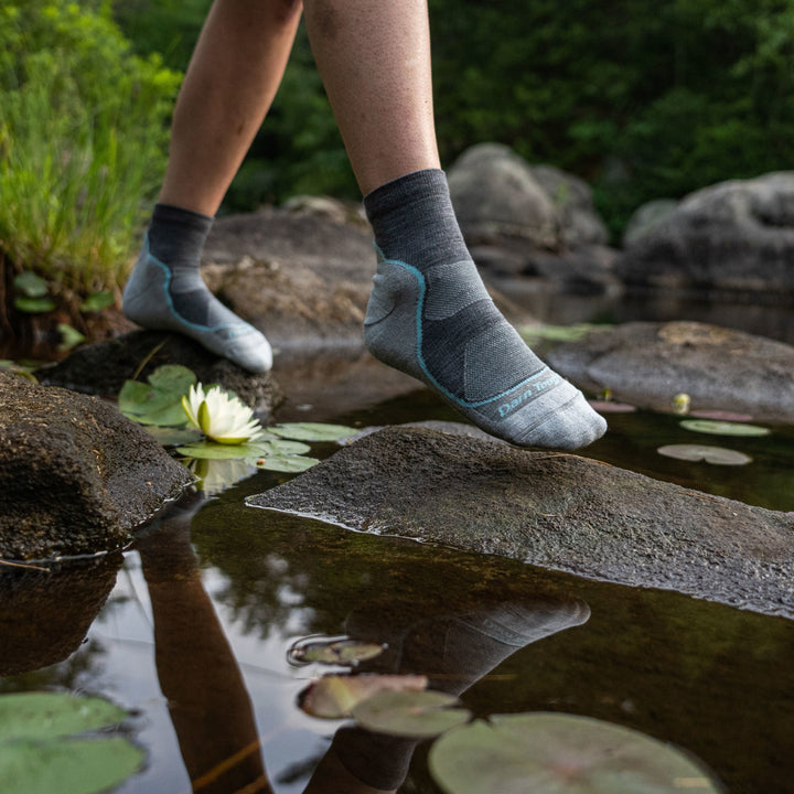 Woman surrounded by water and lily pads, wearing Women's Light Hiker Quarter Lightweight Hiking Socks in Slate