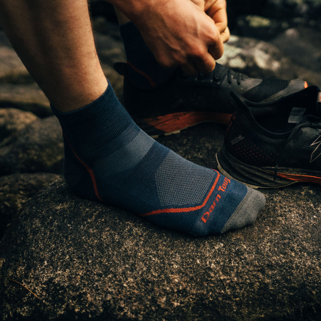 Close up image of a man tying his shoe wearing Light Hiker Quarter Lightweight Hiking Socks in Denim