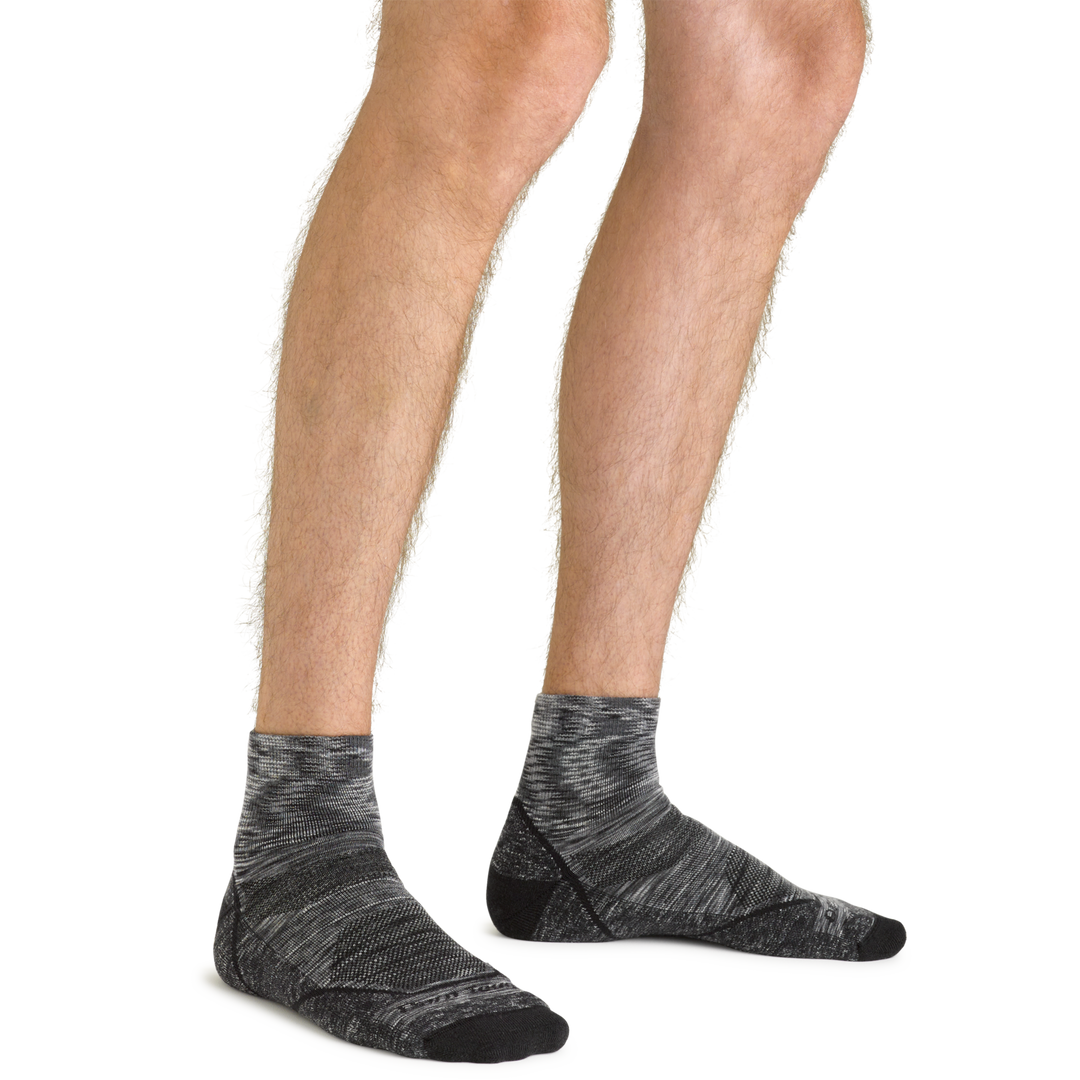 Clos up shot of model wearing the men's light hiker quarter hiking sock in space gray with no shoes on