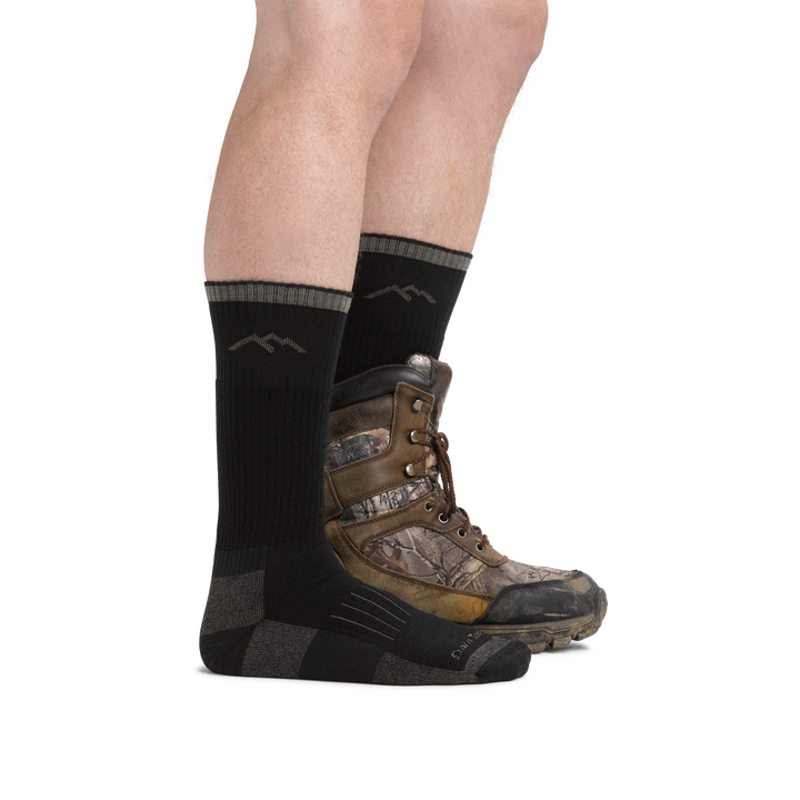 Person wearing Hunter Boot Midweight Hunting Socks in Charcoal and rear foot also wearing a hunting boot