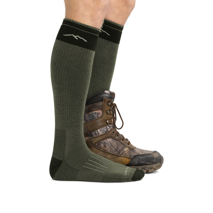 Profile image of a man's legs facing right against a white background wearing Hunter Over the Calf Heavyweight Hunting Socks in Forest with back foot also in a hunting boot