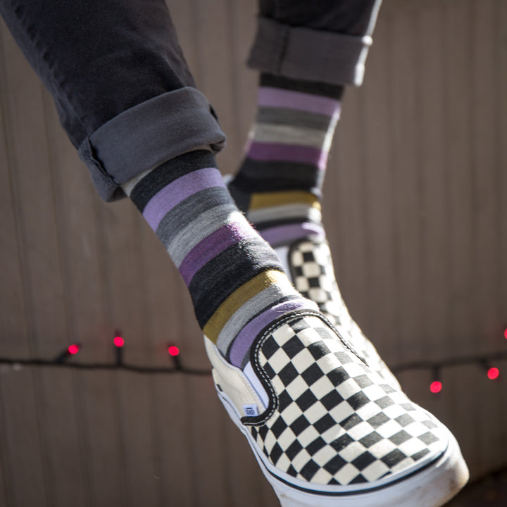 Close up of model wearing Phat Witch striped socks in Gray with black and white checkered Vans and rolled up black jeans.