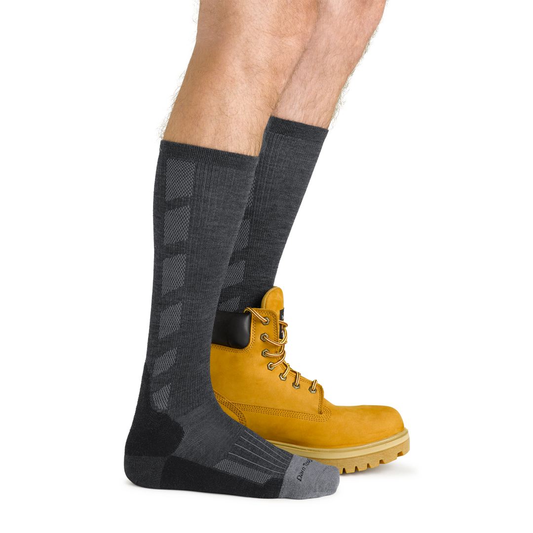 Side studio shot of model wearing men's stanley k mid-calf work sock in gravel gray with khaki work boot on left foot
