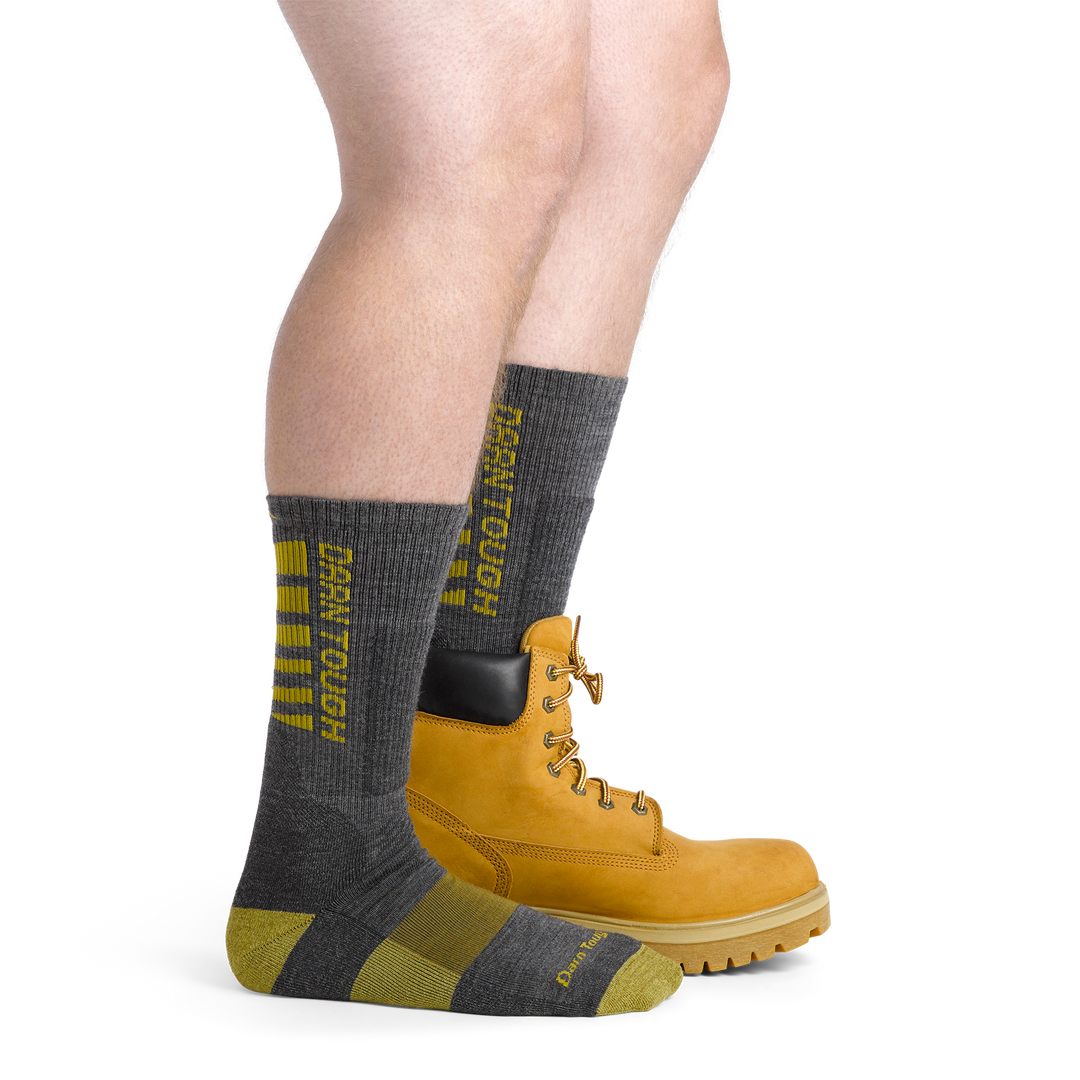 Model wearing the men's Backbone work socks in gray with a work boot on his left foot