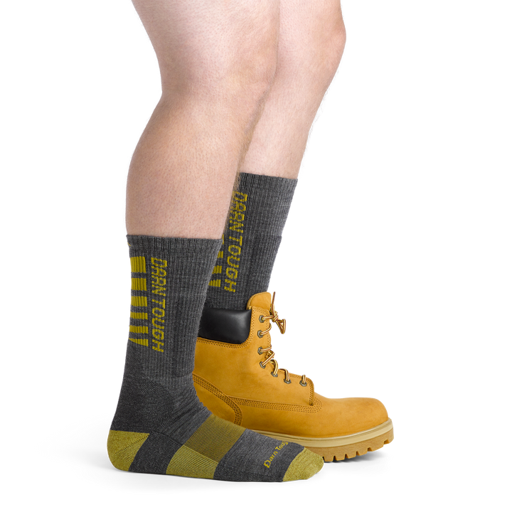 Model wearing the men's Backbone work socks in gray with a work boot on his left foot