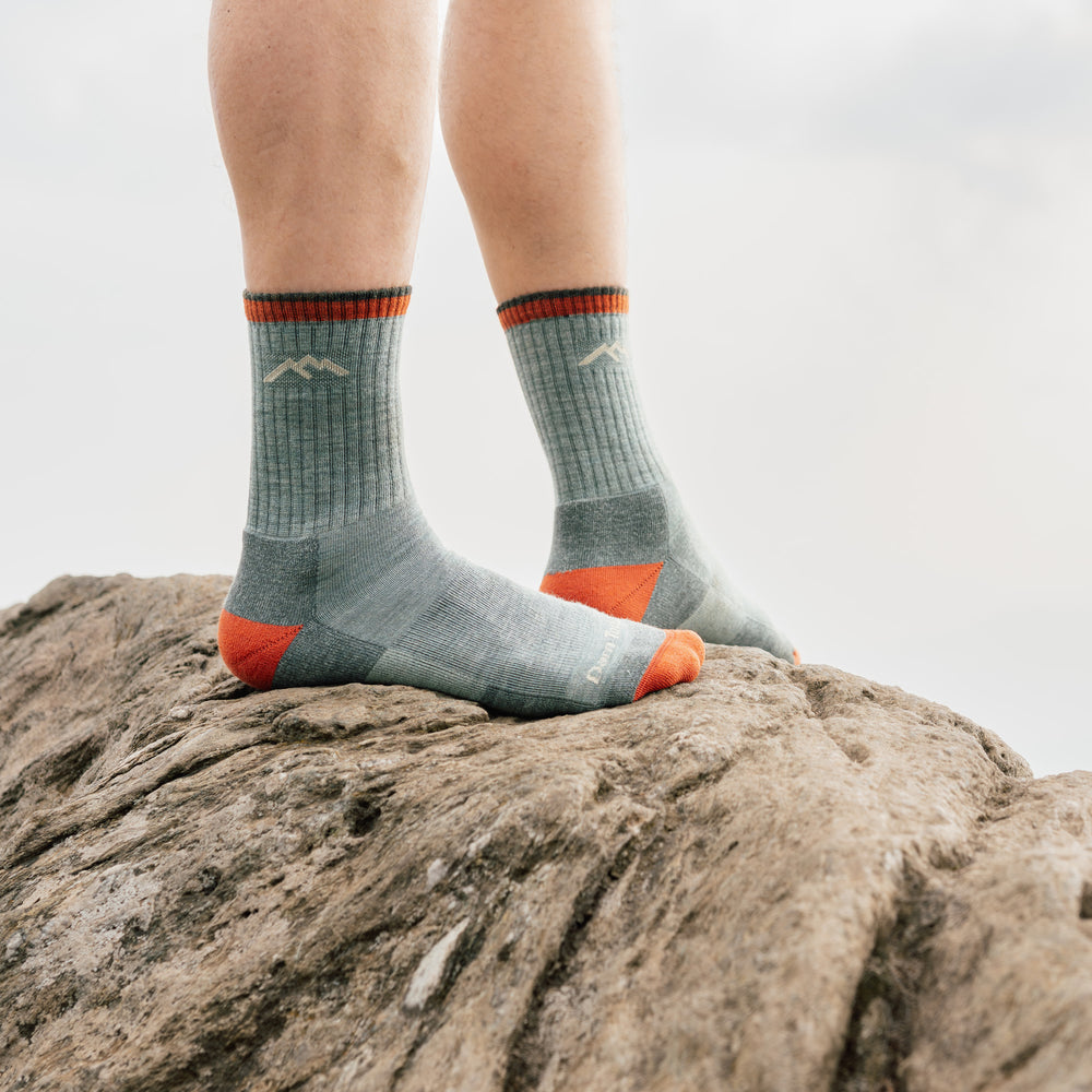model stand on rock wearing the 1466 Limited edition 1466 day sock in sage colorway