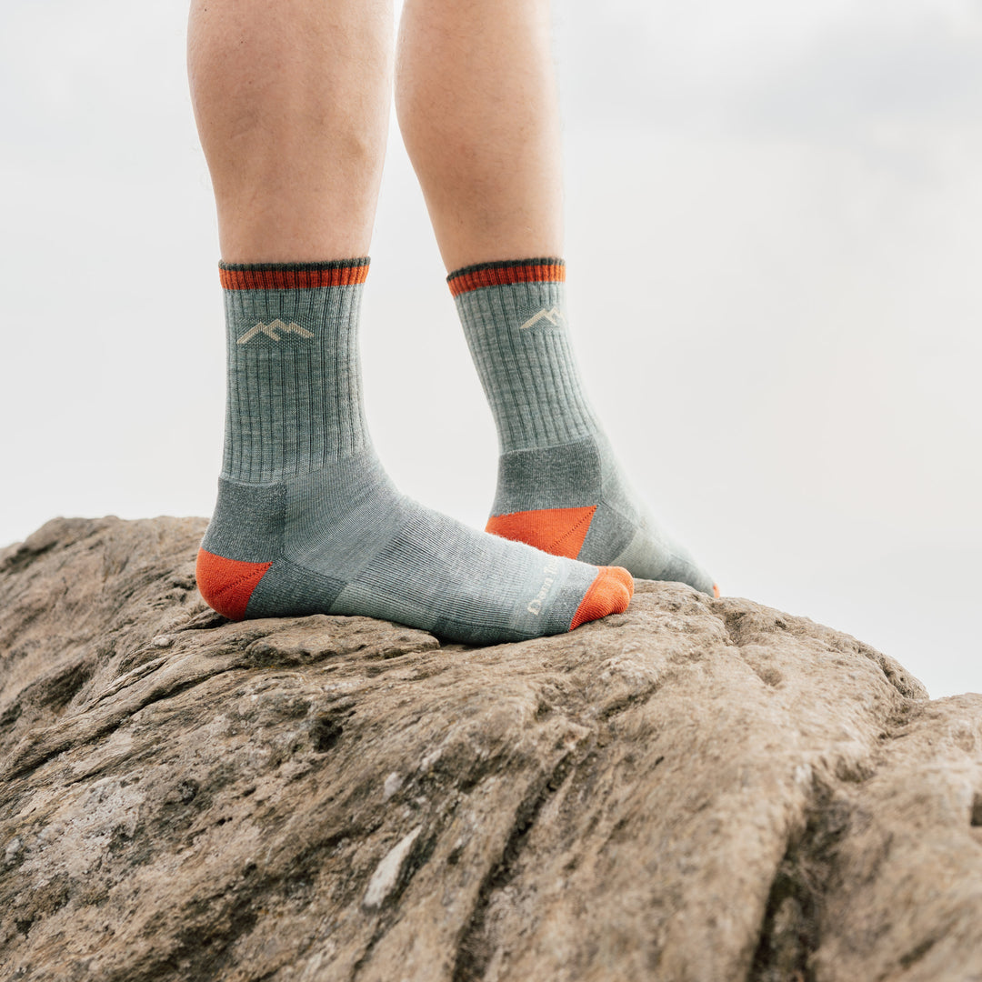 model stand on rock wearing the 1466 Limited edition 1466 day sock in sage colorway