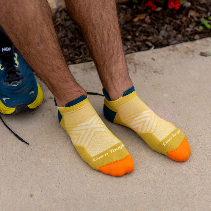 Model wearing the 1039 Limited edition no show in gold with feet on pavement