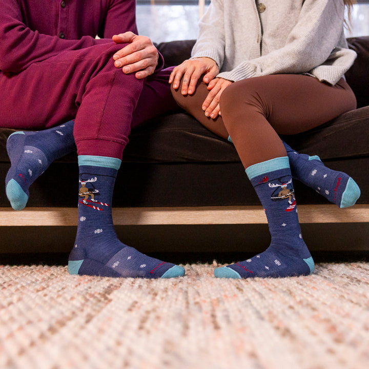 image of two models sitting on couch each wearing a pair of moose on the loose lifestyle socks