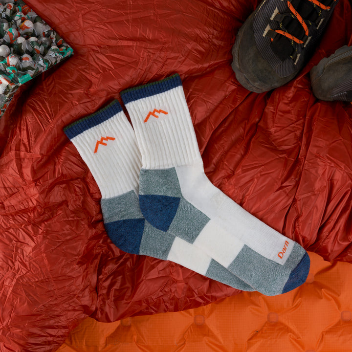 Men's Midweight hiker micro crew in White laying on an orange sleeping bag next to hiking boots