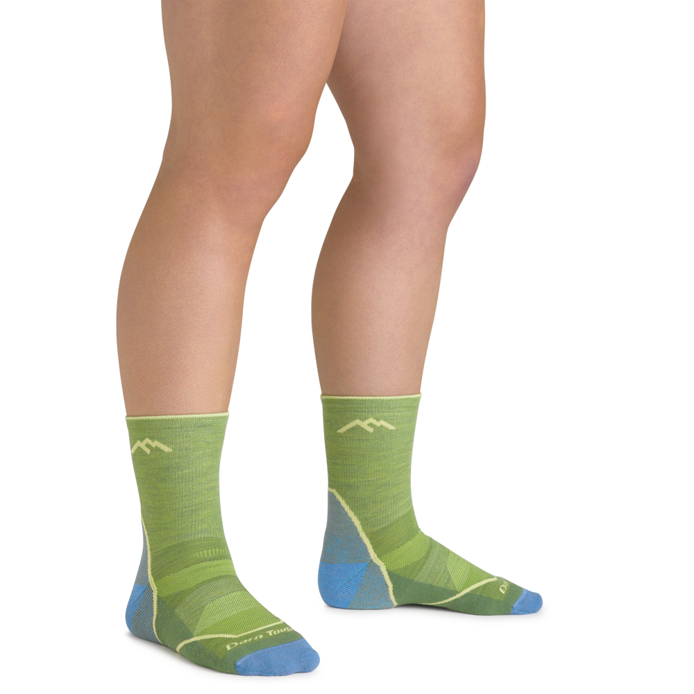 Clos up shot of model wearing the juniors light hiker micro crew hiking sock in willow green with no shoes on