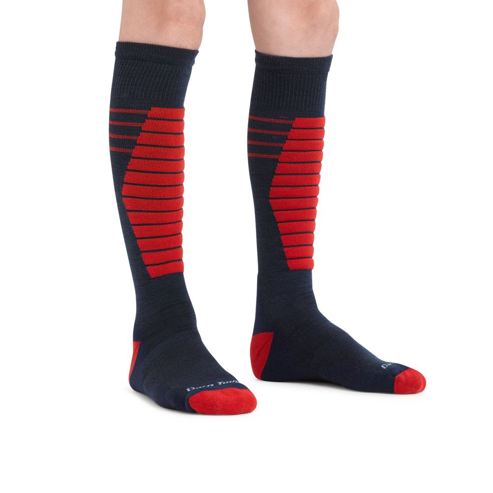 Kid standing barefoot wearing Edge Over the Calf Midweight Ski & Snowboard socks in Eclipse