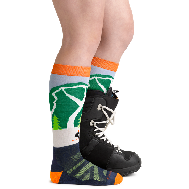 Cow Pow Kids' Snowboard and Ski Sock in Green on foot with snowboard boot