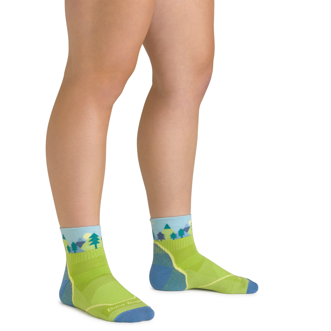Close up shot of model wearing the juniors quest quarter hiking socks in green with no shoes on