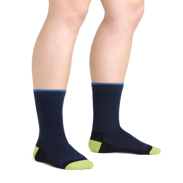 On model image of 3044 Field Trip Kids Hiking socks in Eclipse colorway featuring navy body and green heel and toe accents