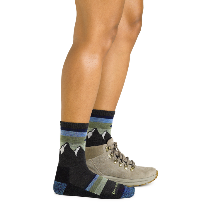 Model wearing women's sunset ledge micro crew hiking sock in charcoal with brown hiking shoe on left foot