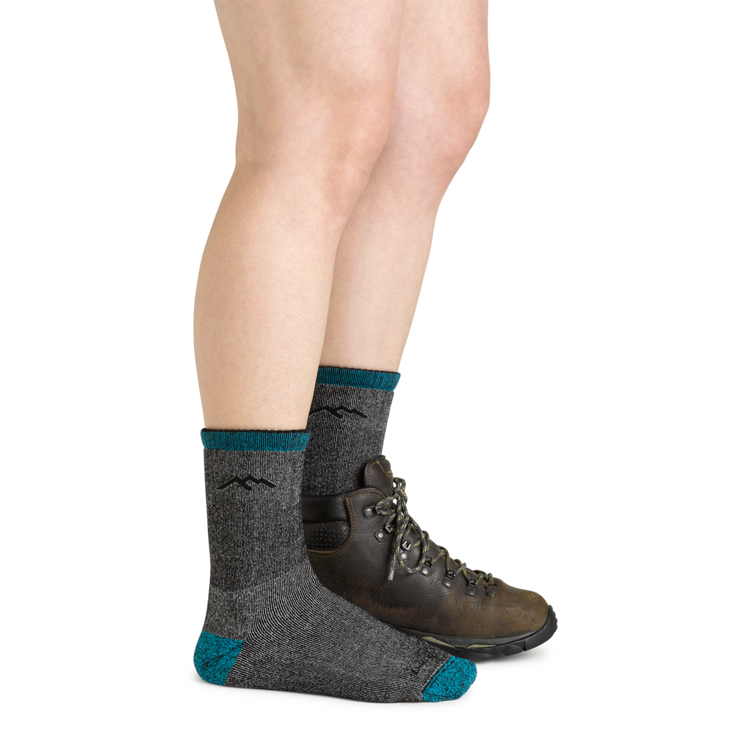 Model wearing the women's mountaineering micro crew hiking socks in midnight with a brown boot on her left foot