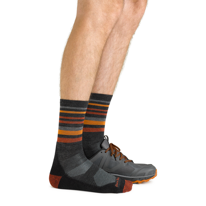 Side shot of model wearing the men's fastpack micro crew hiking socks in charcoal with a gray sneaker on his left foot
