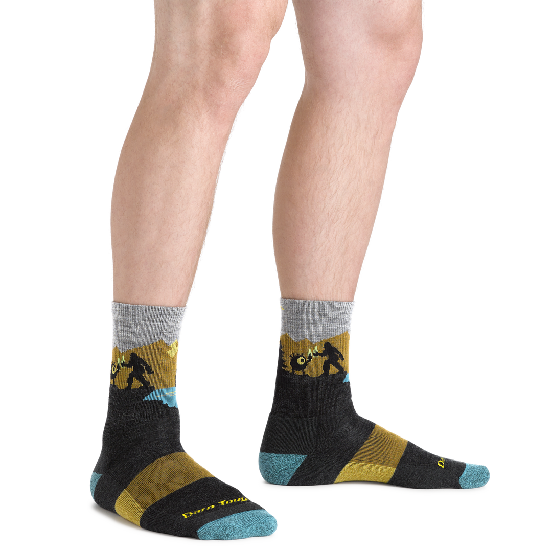  Close up shot of model wearing the men's close encounter micro crew hiking sock in charcoal with no shoes on