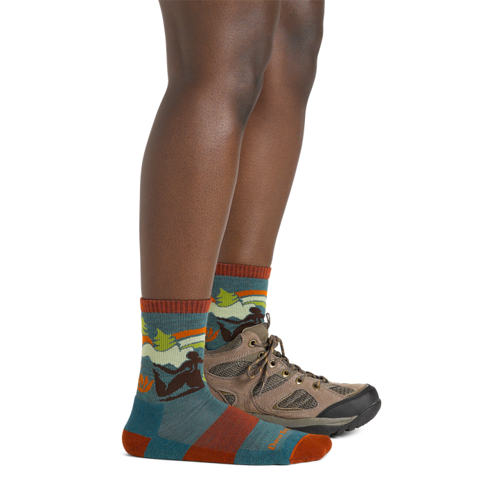 Woman wearing Women's Trailblazer Micro Crew Lightweight Hiking Socks in teal colorway with one foot also wearing a hiking boot