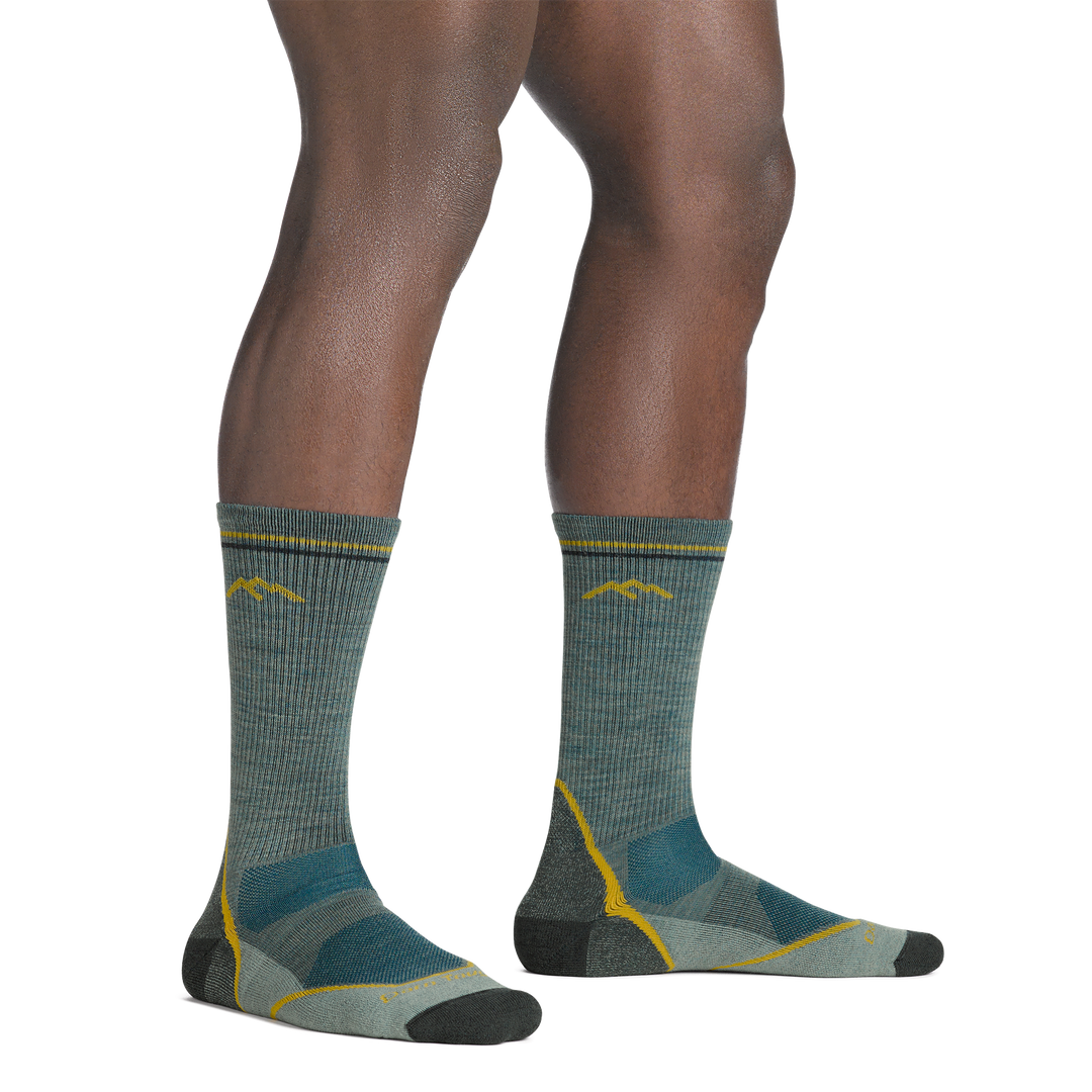 Model standing barefoot wearing the 5028 light hiker boot sock in seafoam green colorway