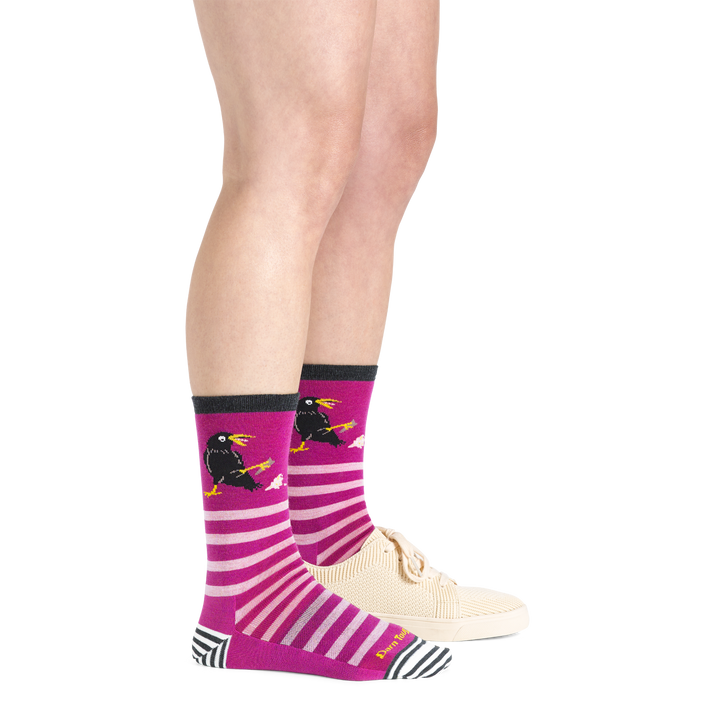  Side shot of model wearing the women's animal haus crew lifestyle sock in clover with a white shoe on her left foot