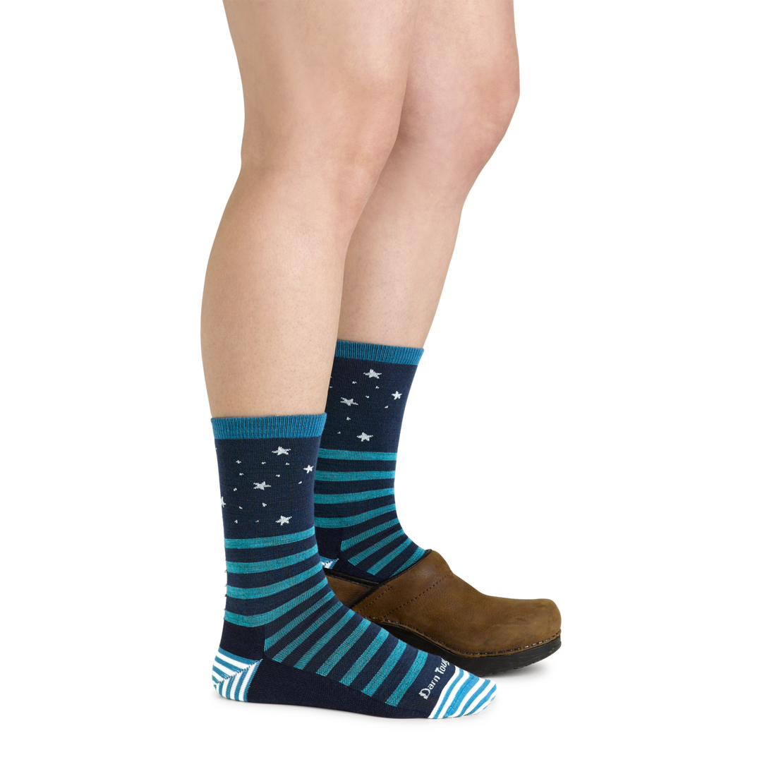 Side shot of model wearing the women's animal haus crew lifestyle sock in eclipse with a brown shot on her left foot