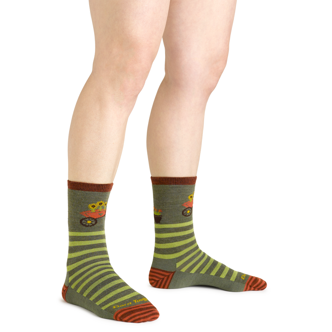 Close up studio shot of model wearing women's animal haus crew lightweight lifestyle sock in herb green