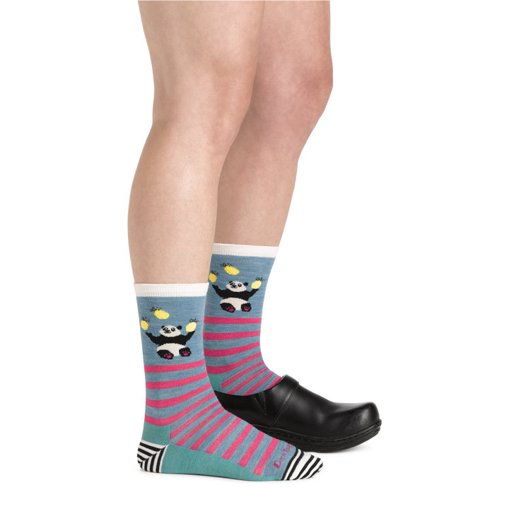 Side shot of model wearing the women's animal haus crew lifestyle sock in Lagoon with a black shoe on her left foot