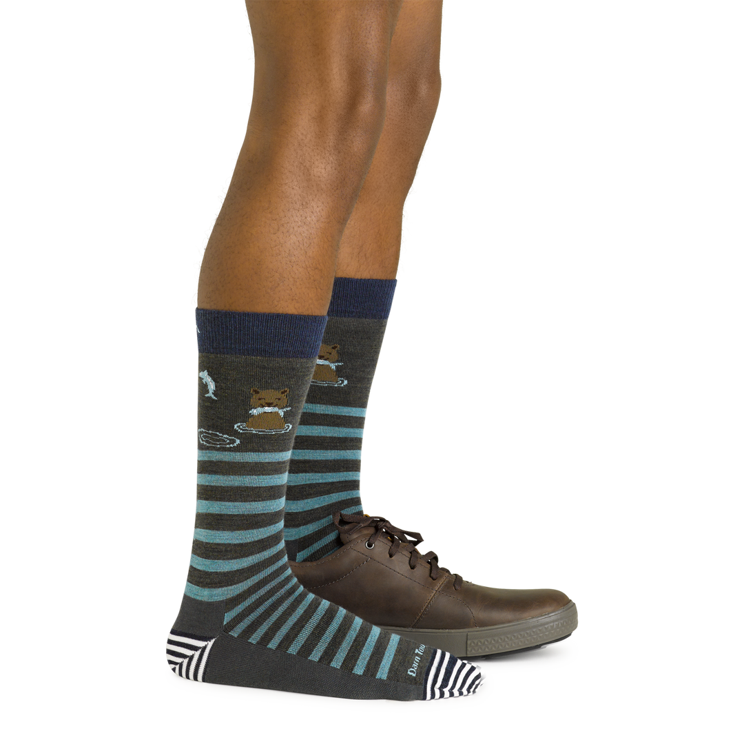 Side shot of model wearing the men's animal haus crew lifestyle sock in forest with a brown shoe on his left foot