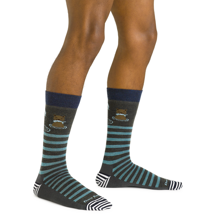 Close up shot of model wearing the men's animal haus crew lifestyle sock in forest green with no shoes on