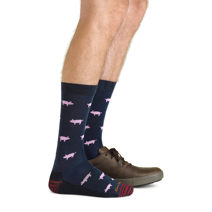 Side studio shot of model wearing men's truffle hog crew lifestyle sock in navy with one brown shoe on left foot