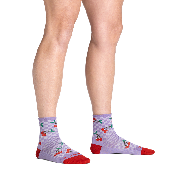 model standing barefoot wearing the 6102 fruit stand shorty lifestyle sock in cherry lavender colorway