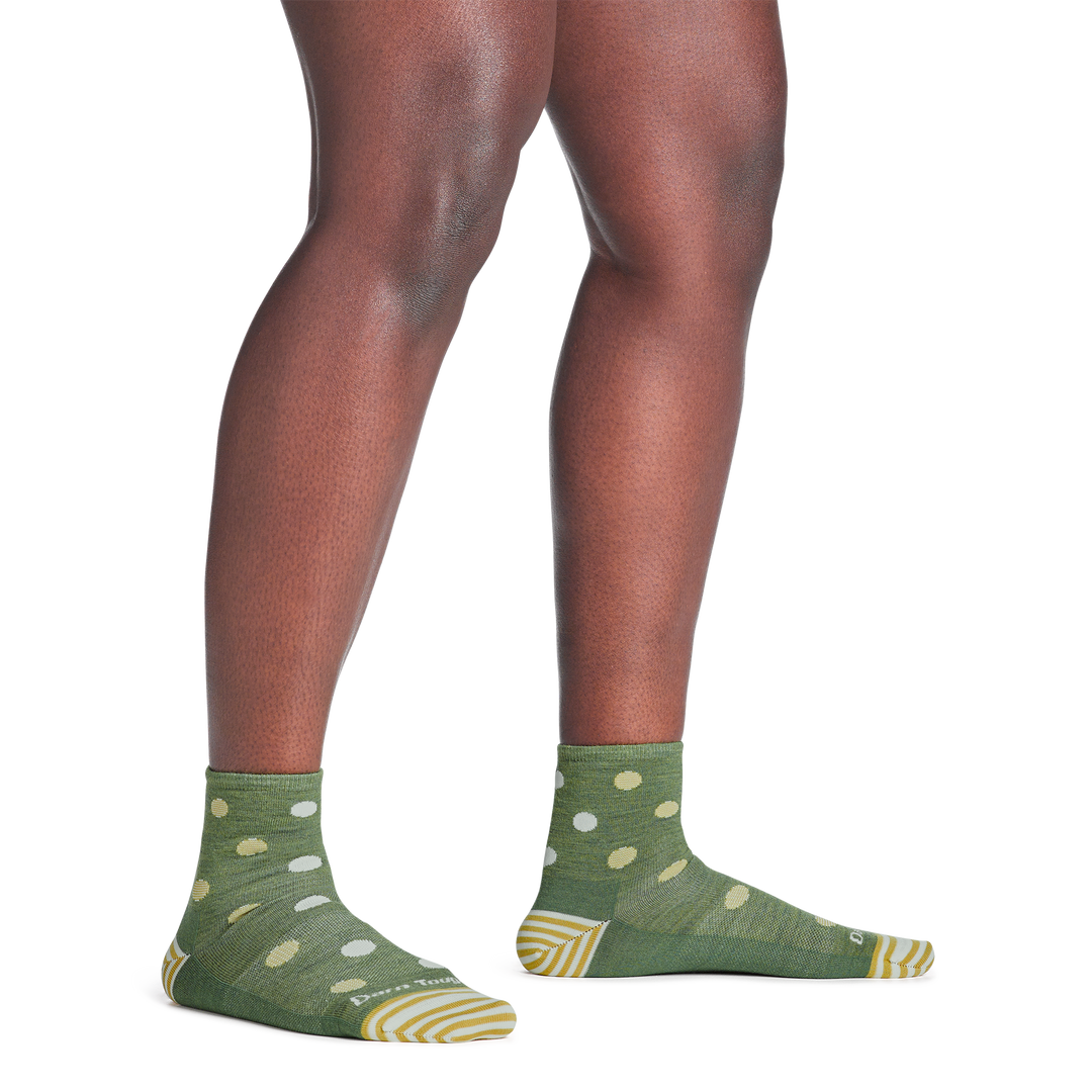 model standing barefoot wearing the 6103 dottie shorty lifestyle sock in willow green colorway