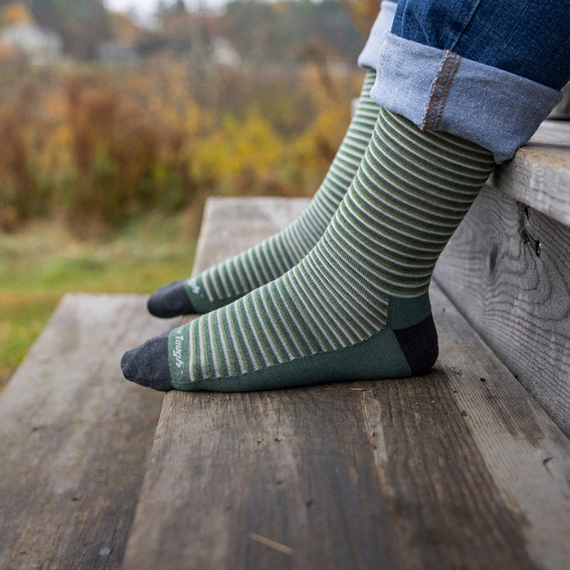 Feet wearing men's crew height socks covered in thin green and white stripes