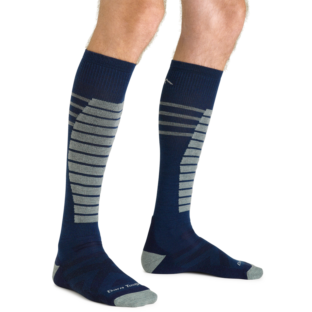 Close up studio shot of model wearing men's edge over-the-calf midweight ski & snowboard sock in midnight blue