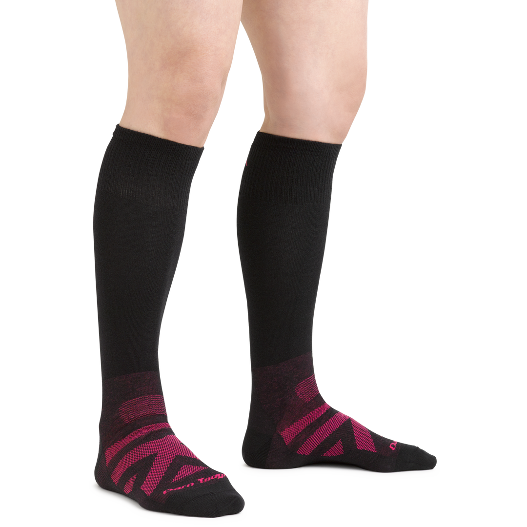 Model wearing women's RFL over-the-calf ski & snowboard sock in color black with pink chevron detailing on the forefoot