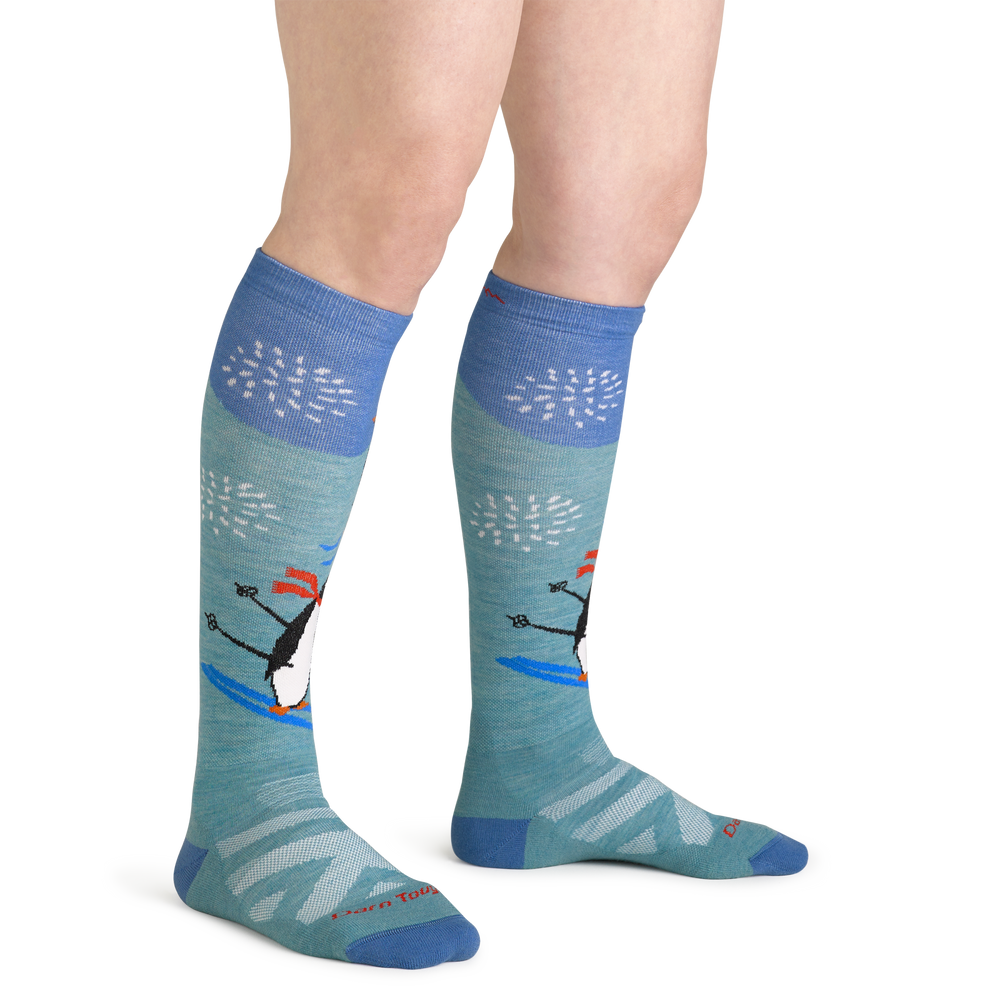 Close up studio shot of model wearing women's penguin peak over-the-calf midweight ski & snowboard sock in aqua