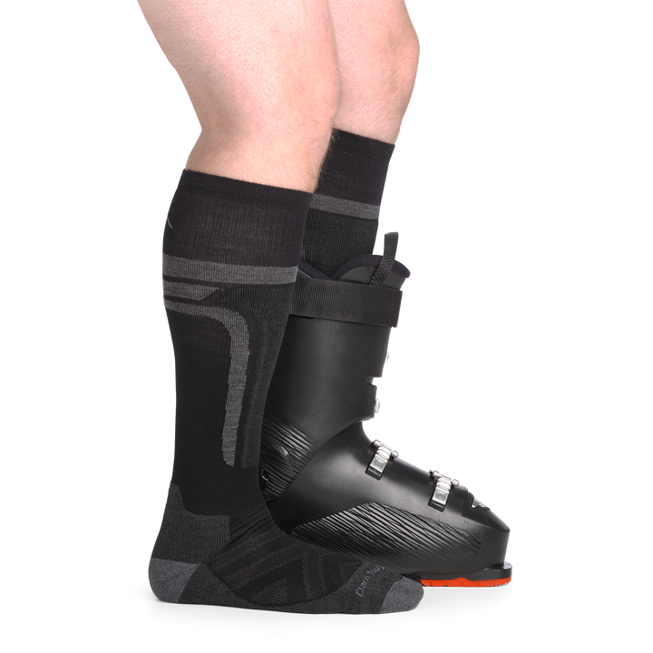 on model image side view back foot in boot wearing the 8053 edge over the calf sock in black colorway