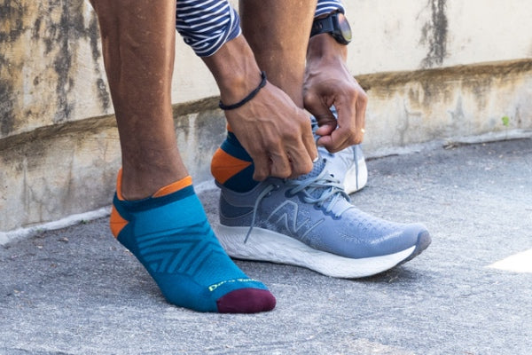 Closeup of person putting on running sneakers over ultralight running socks