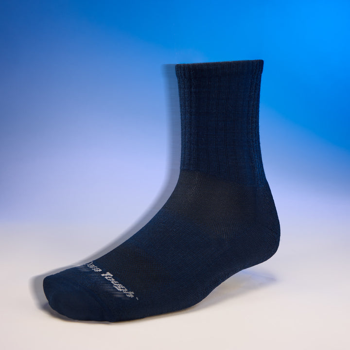 studio shot of mens 6157 the standard micro crew lightweight with cushion in navy with blue background 
