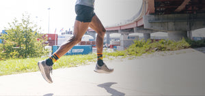 A runner wearing darn tough socks for runners with bold stripes and an ultralight design