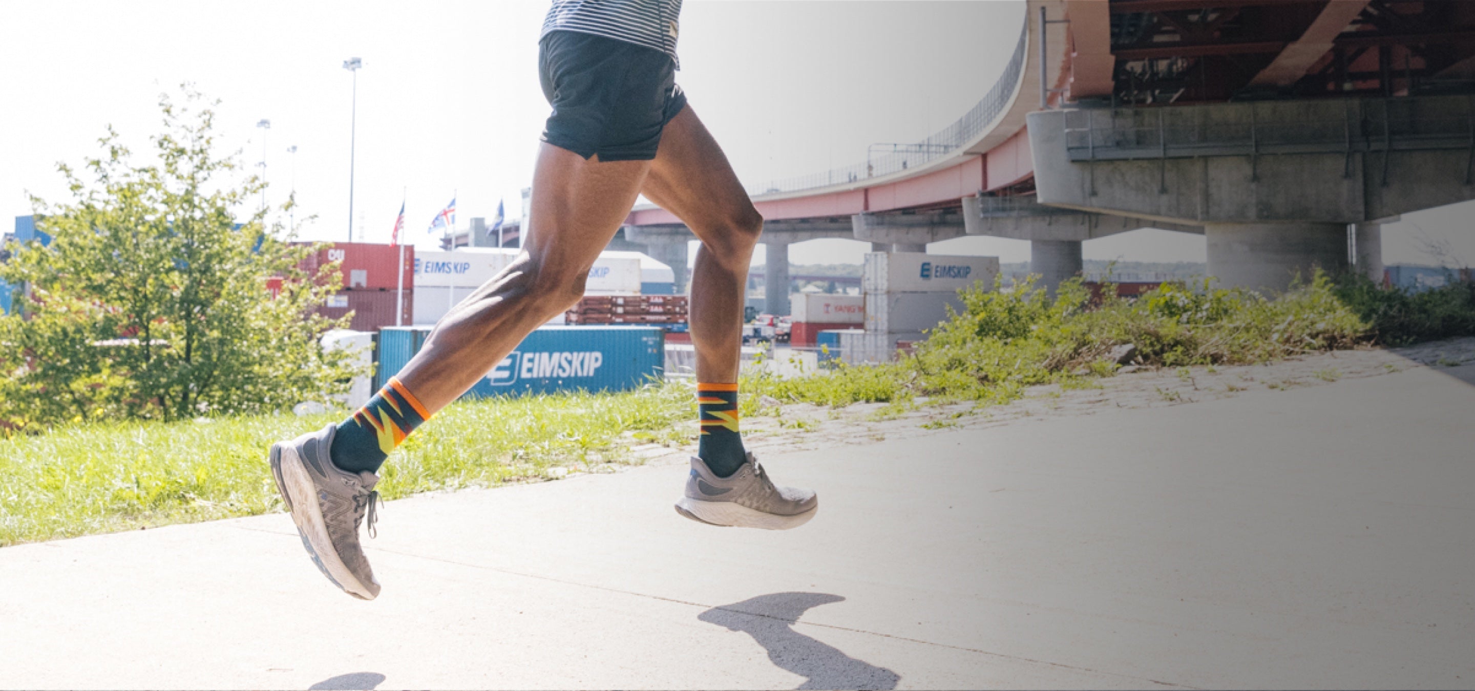 A runner wearing darn tough socks for runners with bold stripes and an ultralight design