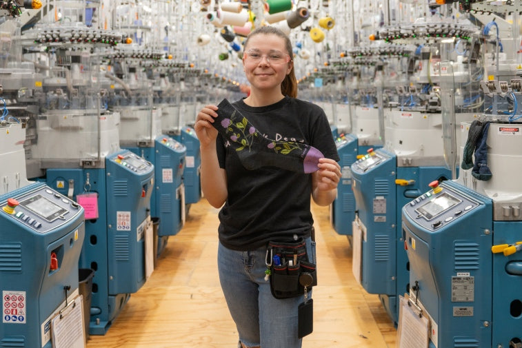 Alissa holding up her favorite sock to give as a gift - the Blossom with clover flowers