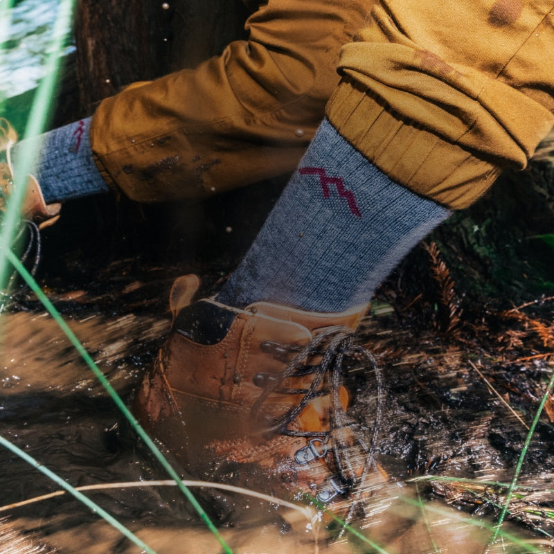 A hiker wearing darn tough socks tripping on a very muddy trail