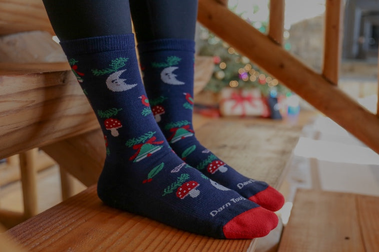 Shop Holiday Socks - feet wearing socks with a fun mistletoe and bell design