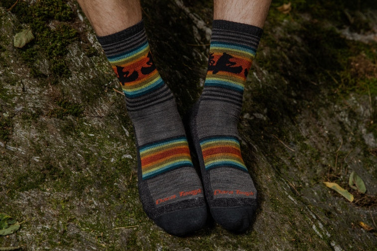 Shop Best Selling Darn Tough Socks - feet wearing socks with canoeing bears on them