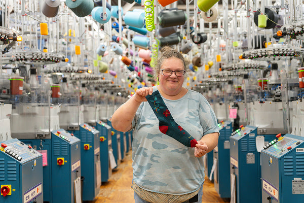Amy showing off the Mistle-Toe sock, covered in poinsettias and mistletoe designs