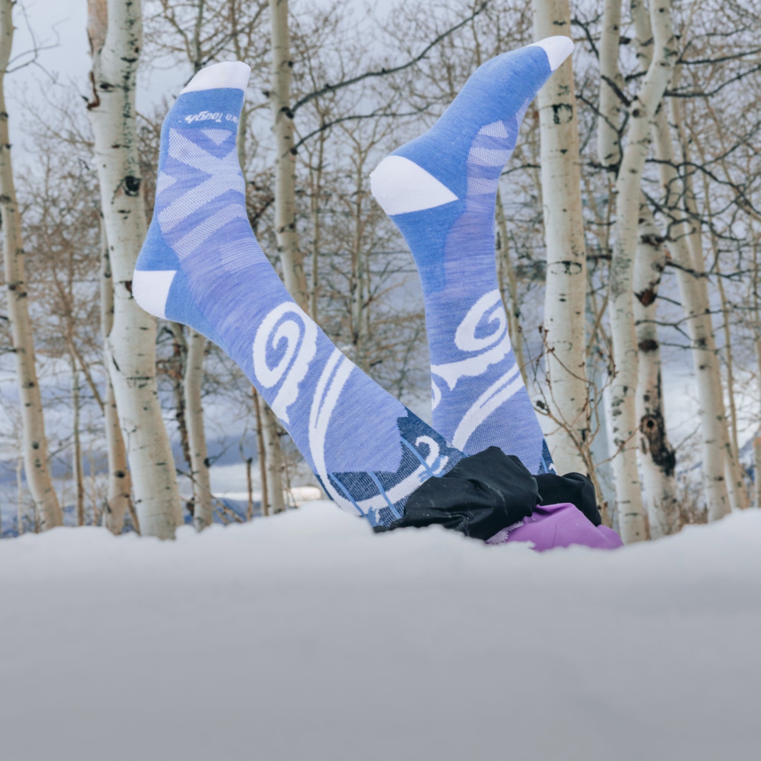 Image of a model in the snow wearing the women's swirlwind over-the-calf ski sock