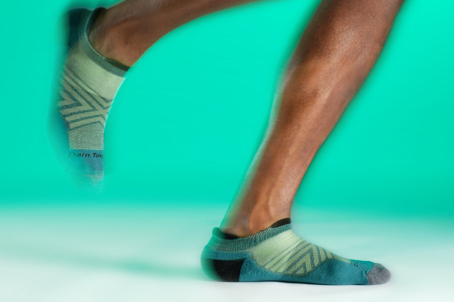 Feet wearing the Darn Tough No Show Tab Running Sock in green